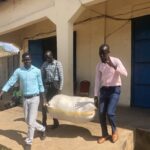 ujoss and number one citizen staff carrying their donation